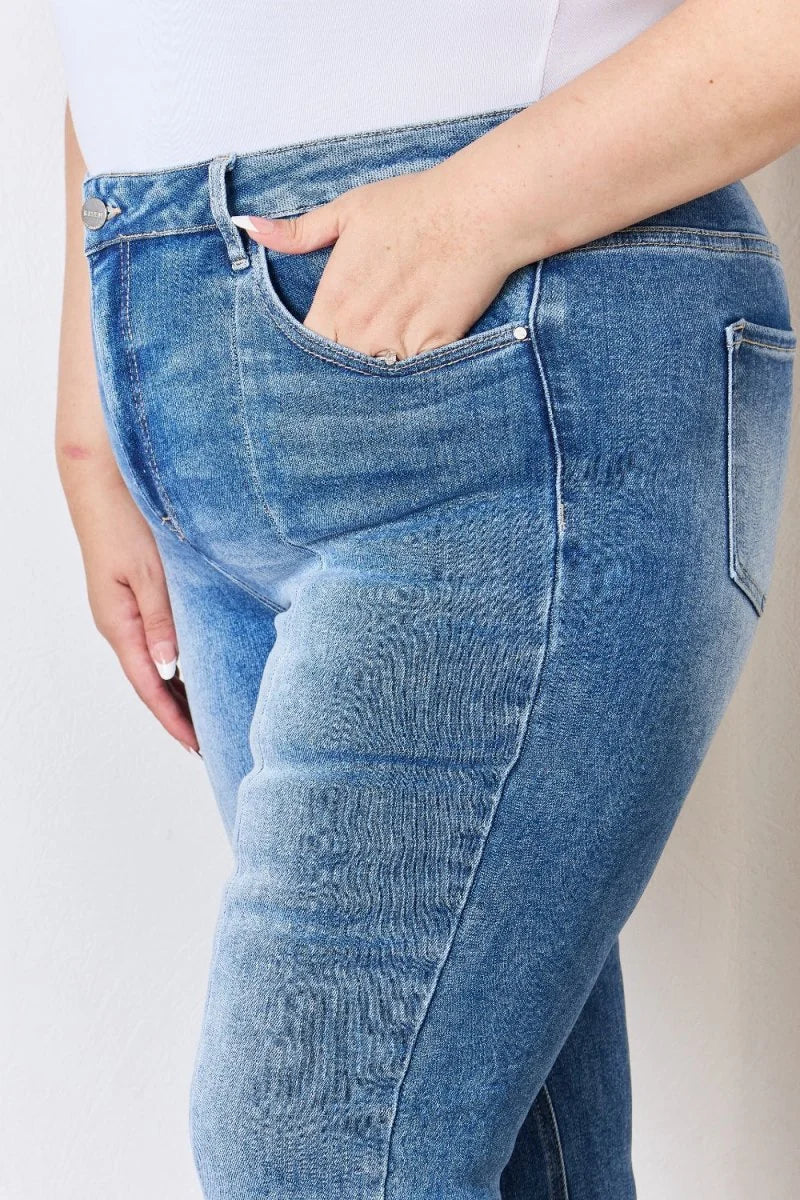Close-up of light wash denim jeans with a hand in the pocket, showing texture and stitching details.
