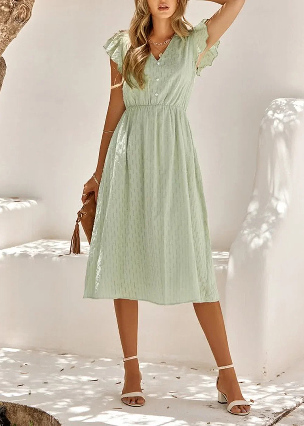 Light green cotton dress with a subtle textured pattern, flutter sleeves, and a button-front V-neck on a model.