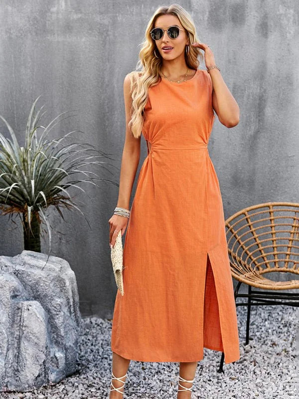 Orange sleeveless maxi dress with a thigh-high slit, cinched waist, and white lace-up sandals on a model.