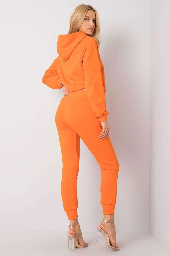 Orange cotton-spandex joggers with a regular fit, shown on a model wearing clear heels.