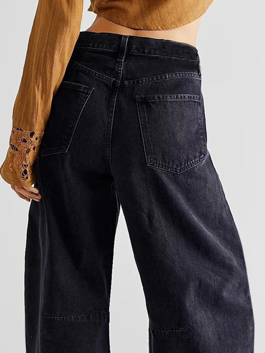 High-waisted black wide-leg jeans with visible stitching detail on the legs, shown from the back.
