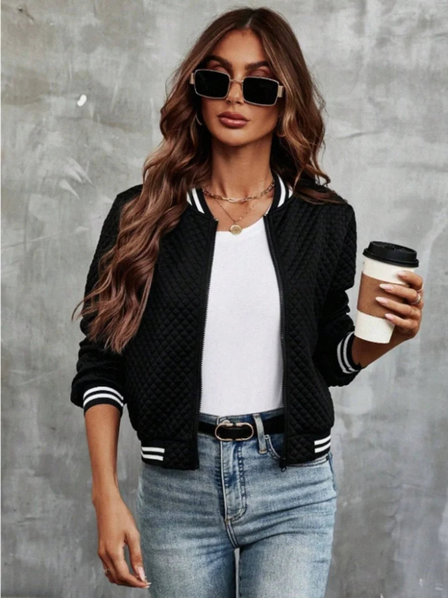 Black quilted bomber jacket with white striped cuffs and collar, worn by a model.