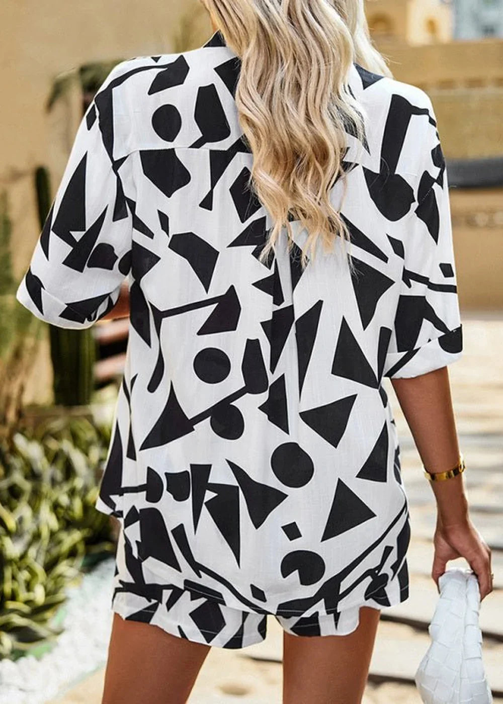Black and white abstract print viscose short suit with rolled sleeves on model.