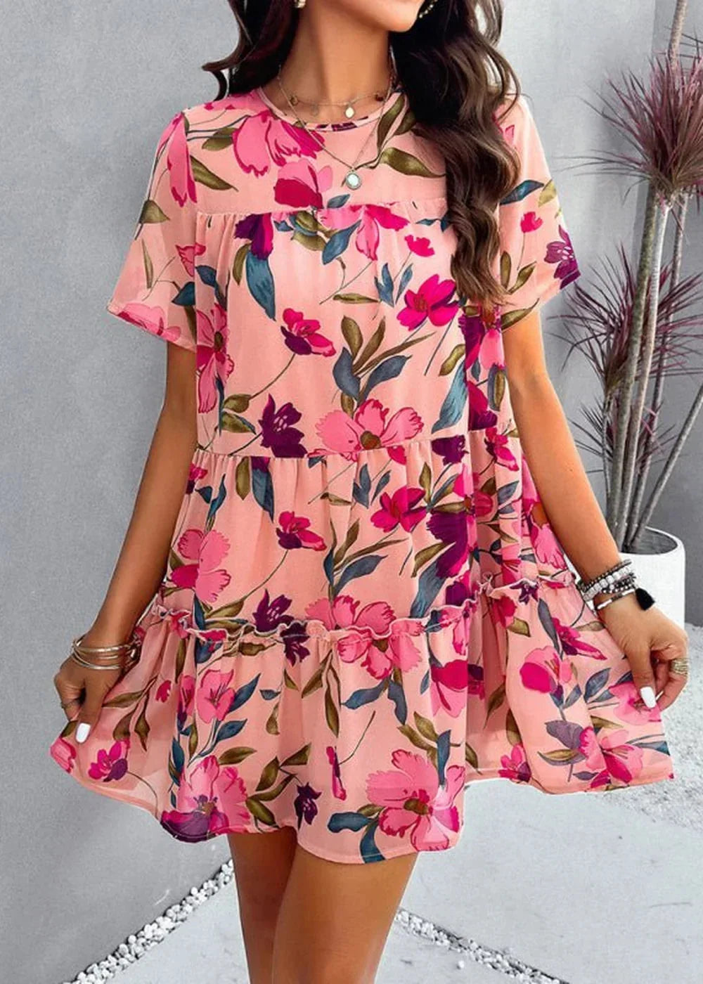 Pink floral print tiered mini dress with flutter sleeves and ruffled hem.