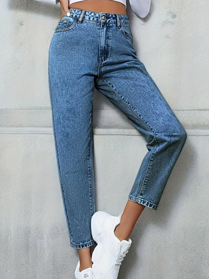 Medium wash distressed denim jeans with a relaxed fit, cropped at the ankle.