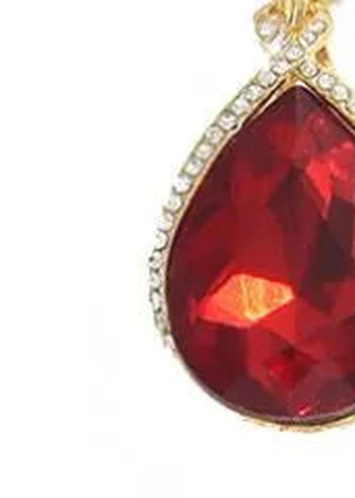 Close-up of 18k gold teardrop pendant with sparkling rhinestones.